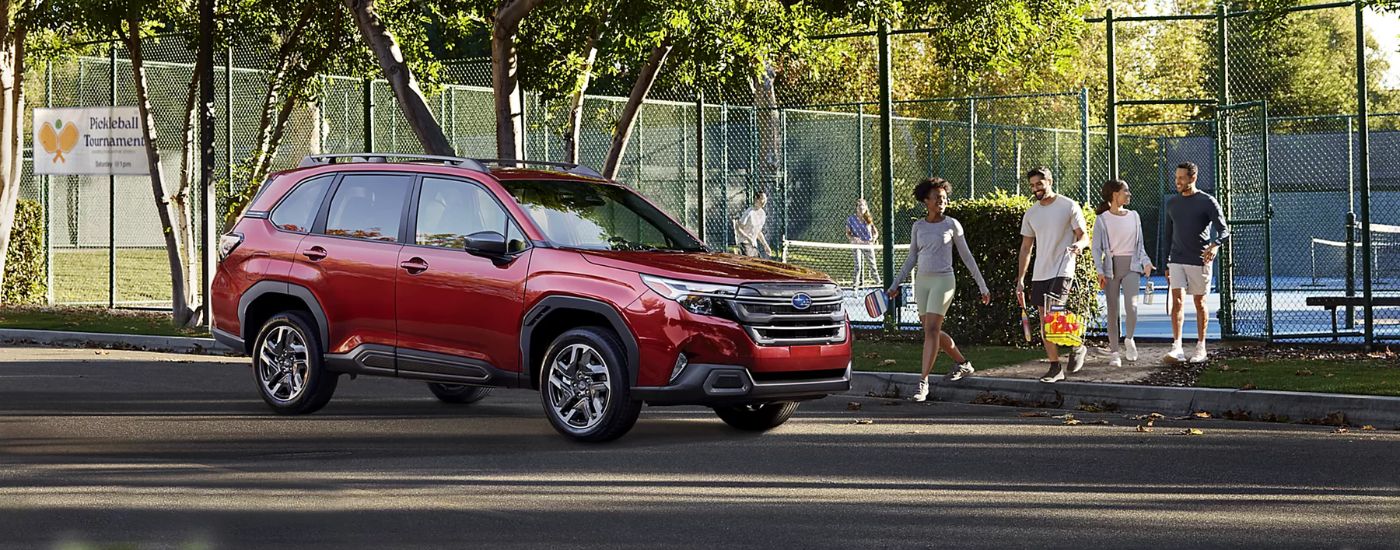 A red 2026 Subaru Forester Limited parked by a pickleball court.