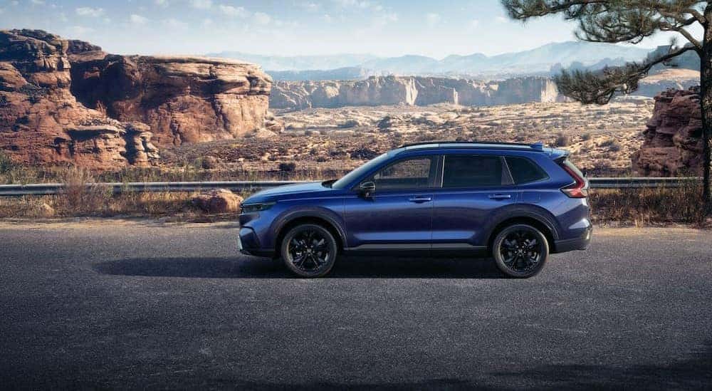 A blue 2026 Honda CR-V driving on a highway.