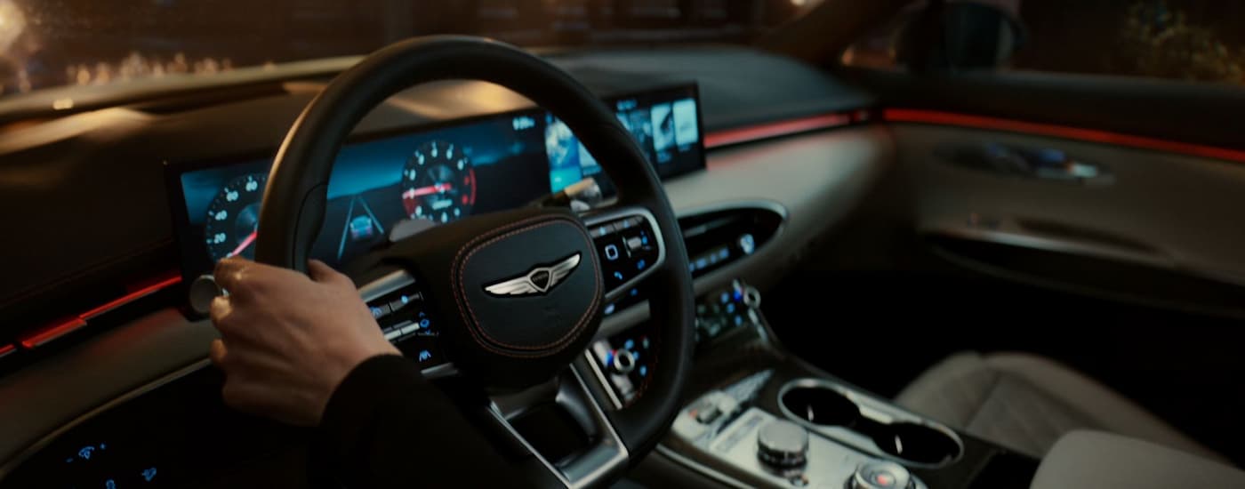 Person driving in a 2026 Genesis G70 on a city street