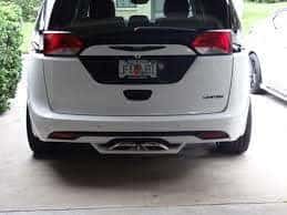 Rear of a white minivan showing a custom exhaust