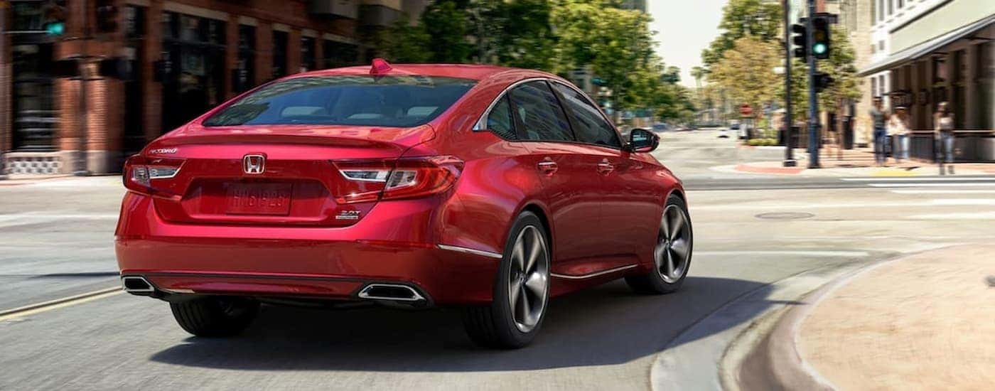 A red 2020 Honda Accord Touring is shown from the rear driving to a get an oil change in Rochester, NY.