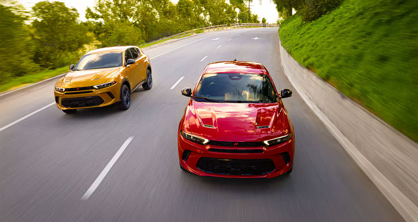 A red and yellow SUV driving on the road.