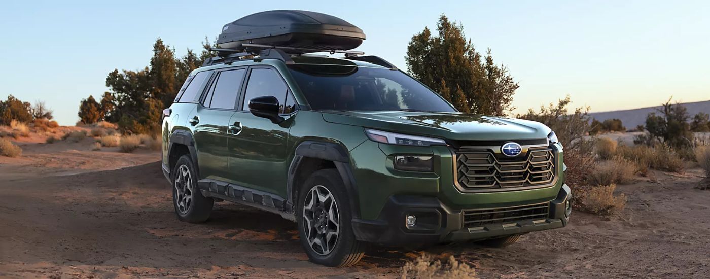 A green 2026 Subaru Outback Touring driving off road.