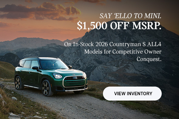 Front passenger side view of a MINI Countryman  driving on a mountainous road.