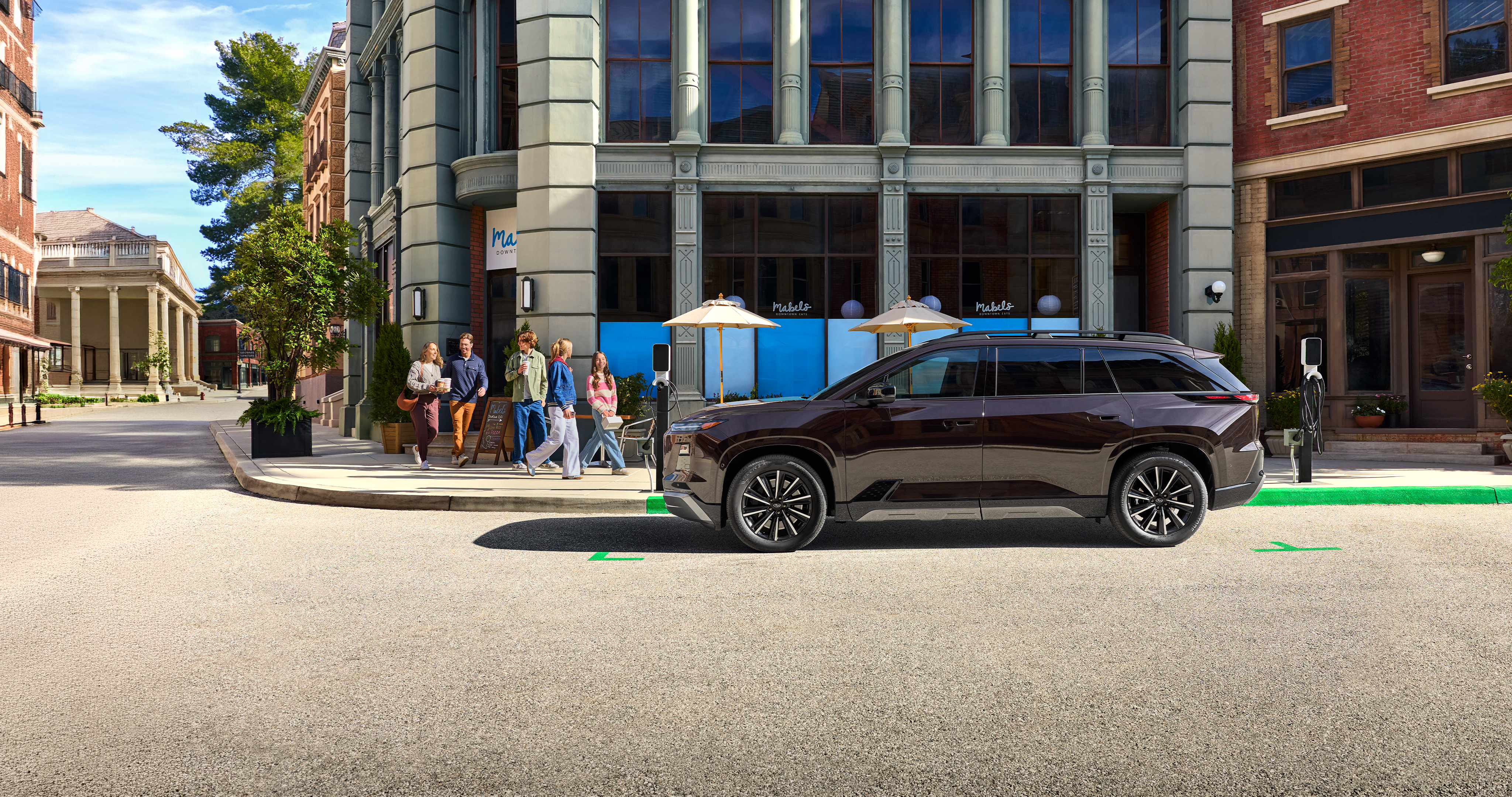 609_27_Subaru_EV_Coffee_Run_lg_xl.png / 2028 Subaru EV SUV parked at curb outside of urban coffee shop.
