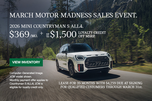 Front passenger view of a white MINI Countryman driving on a mountainous road.