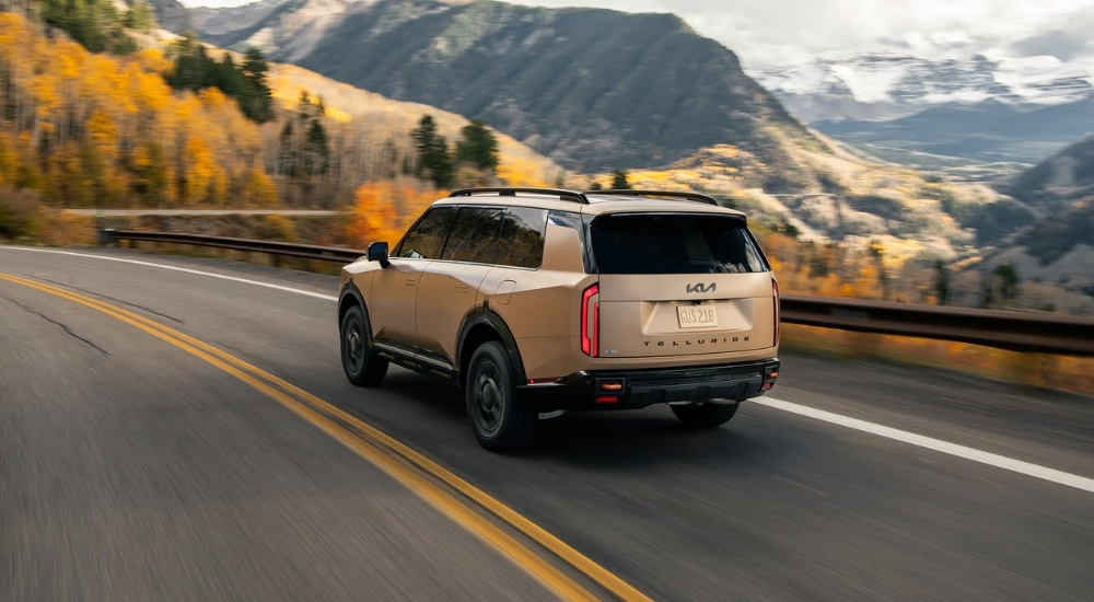 Tan 2027 Kia Telluride driving on a highway