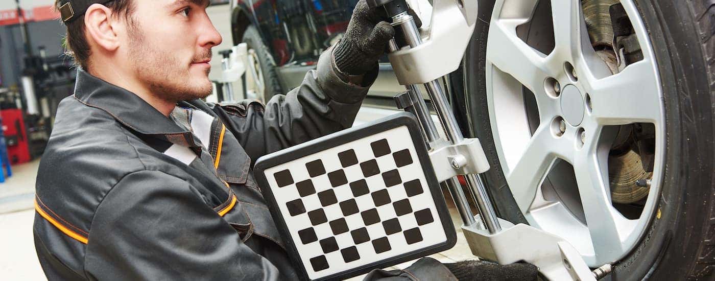 A mechanic is shown putting a target on a wheel.