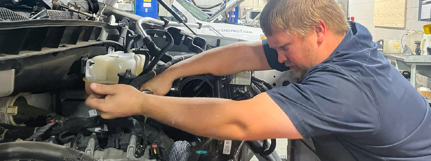 Automotive technician working on a vehicle engine bay