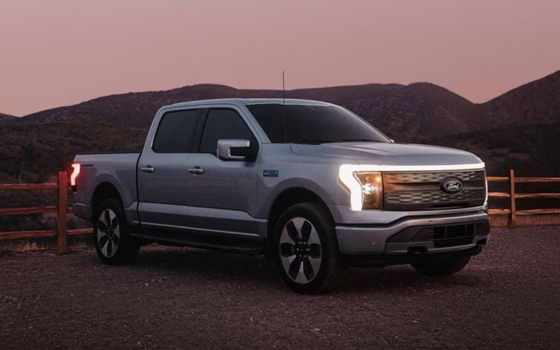 image of ford f-150 towing trailer with construction equipment