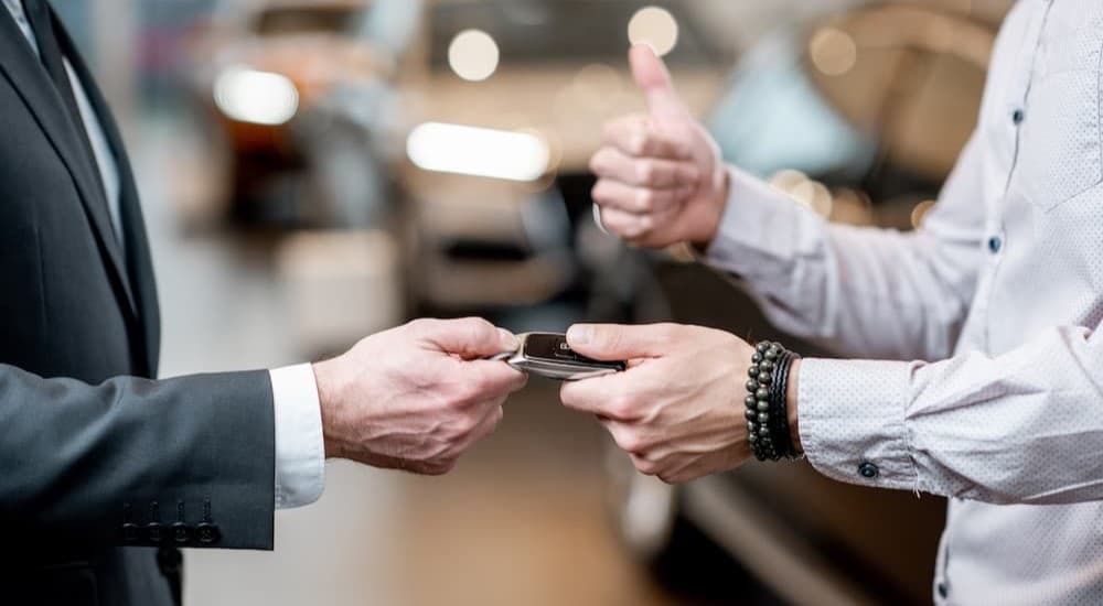 Two people handing off a key fob.