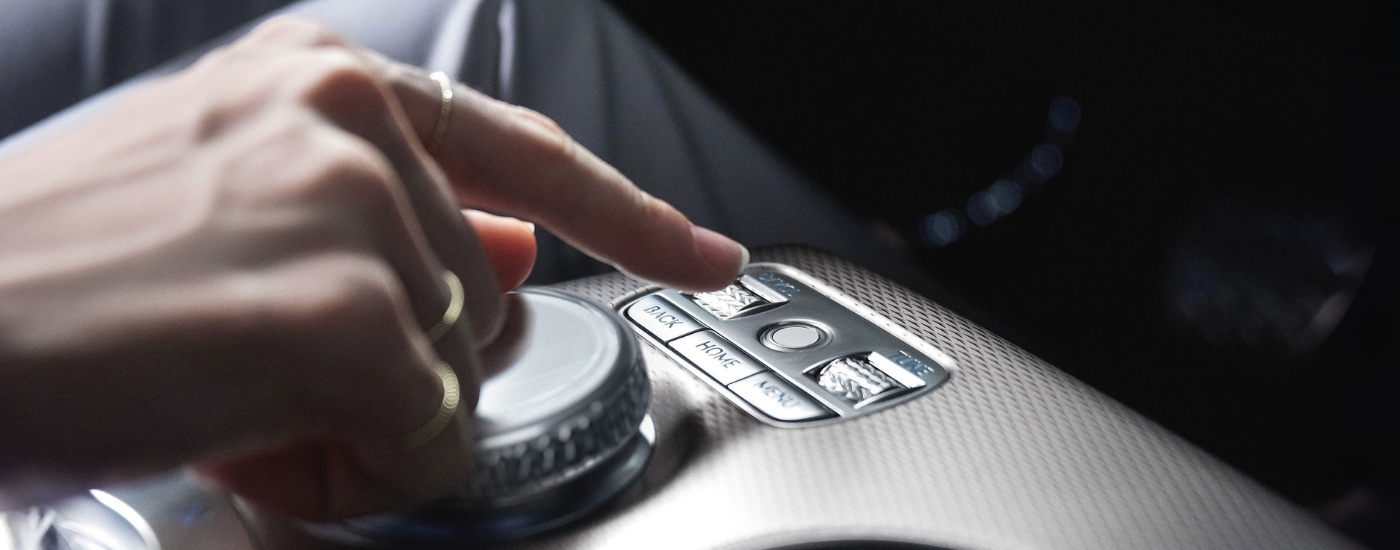 Person using controls in a 2025 Genesis GV60 at a Genesis dealer near Kissimmee.