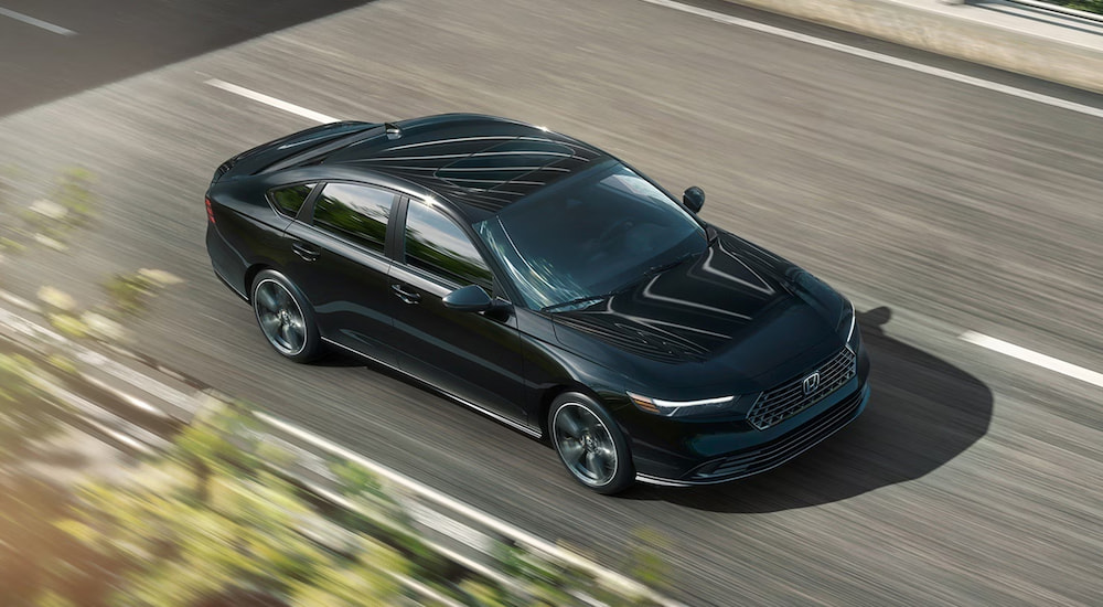 Black 2026 Honda Accord driving down an open road.