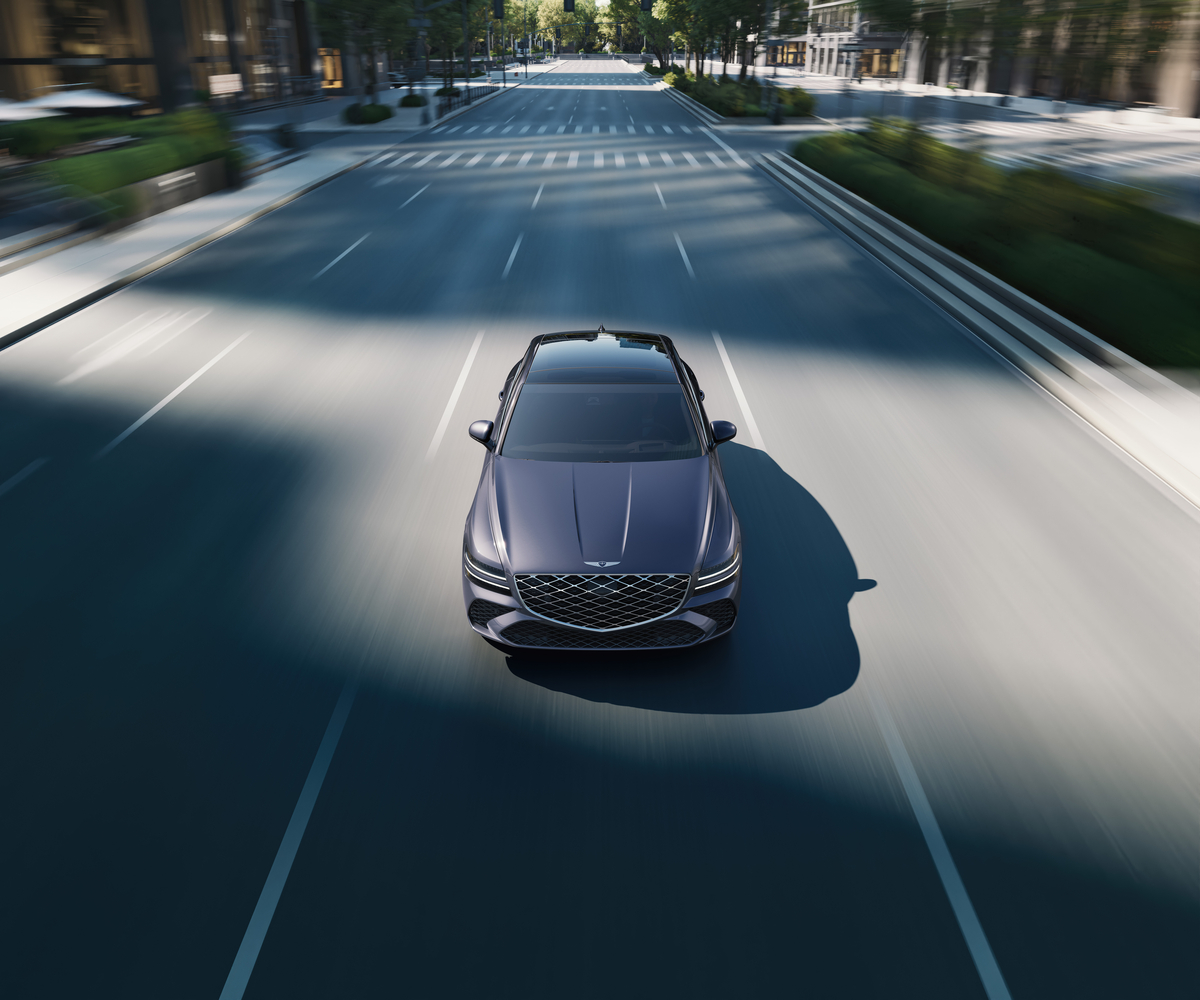 Front high angle view of Genesis G80 in Ceres Blue in motion driving on city street