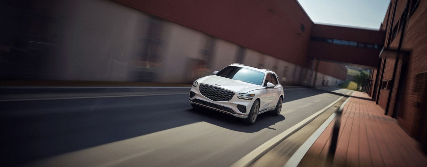 White 2026 Genesis GV70 driving down a street