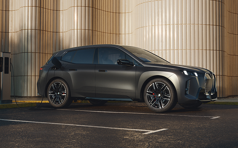 The BMW iX M70 in deep grey paint parked.