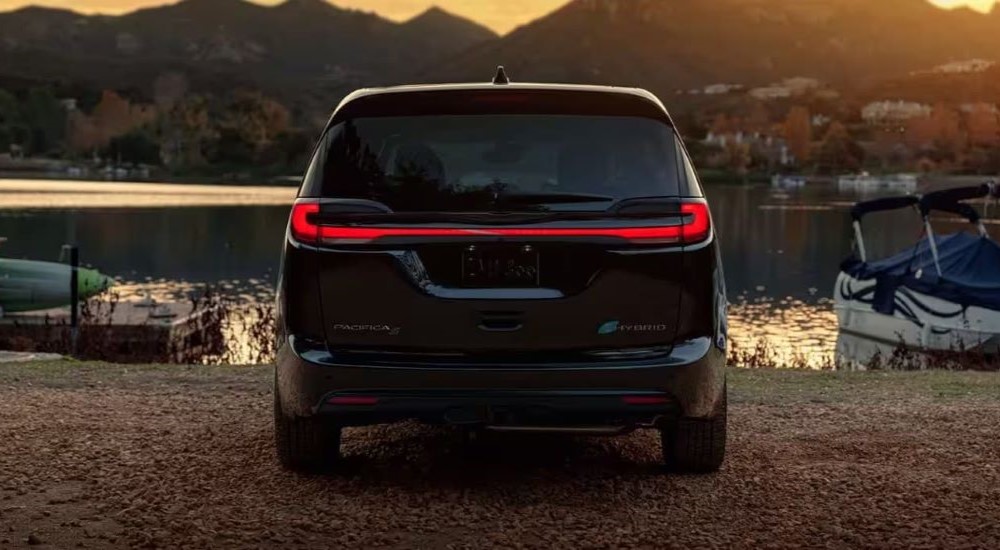 A black 2023 Chrysler Pacifica S Hybrid is shown parked near a lake.