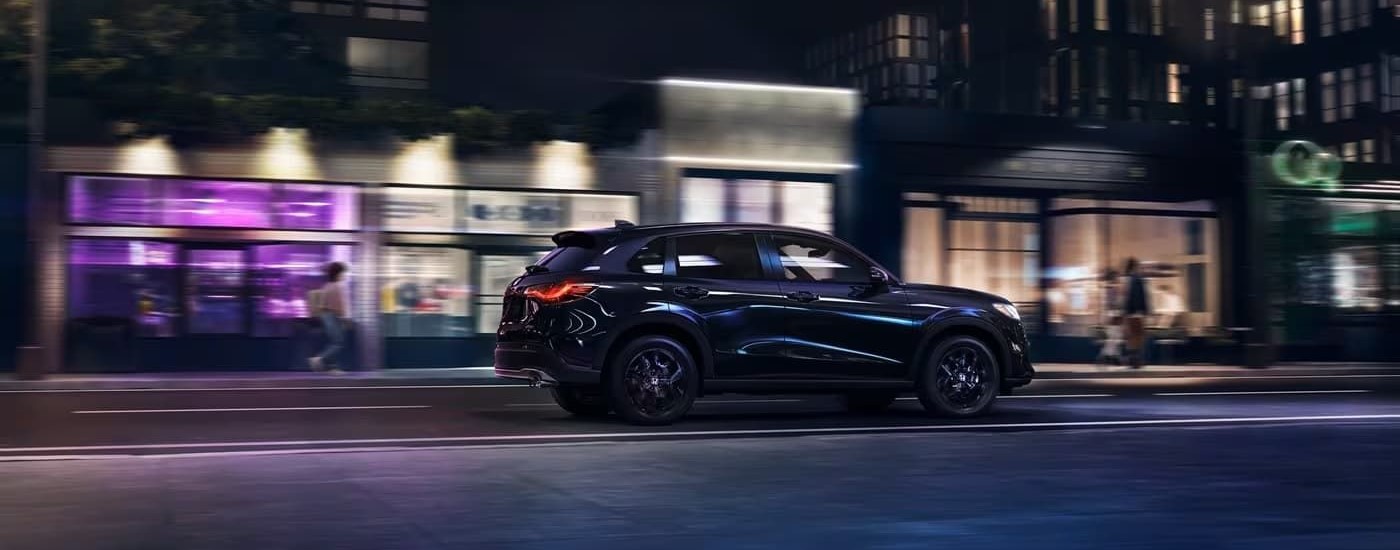 Black 2023 Honda HR-V driving on a city street