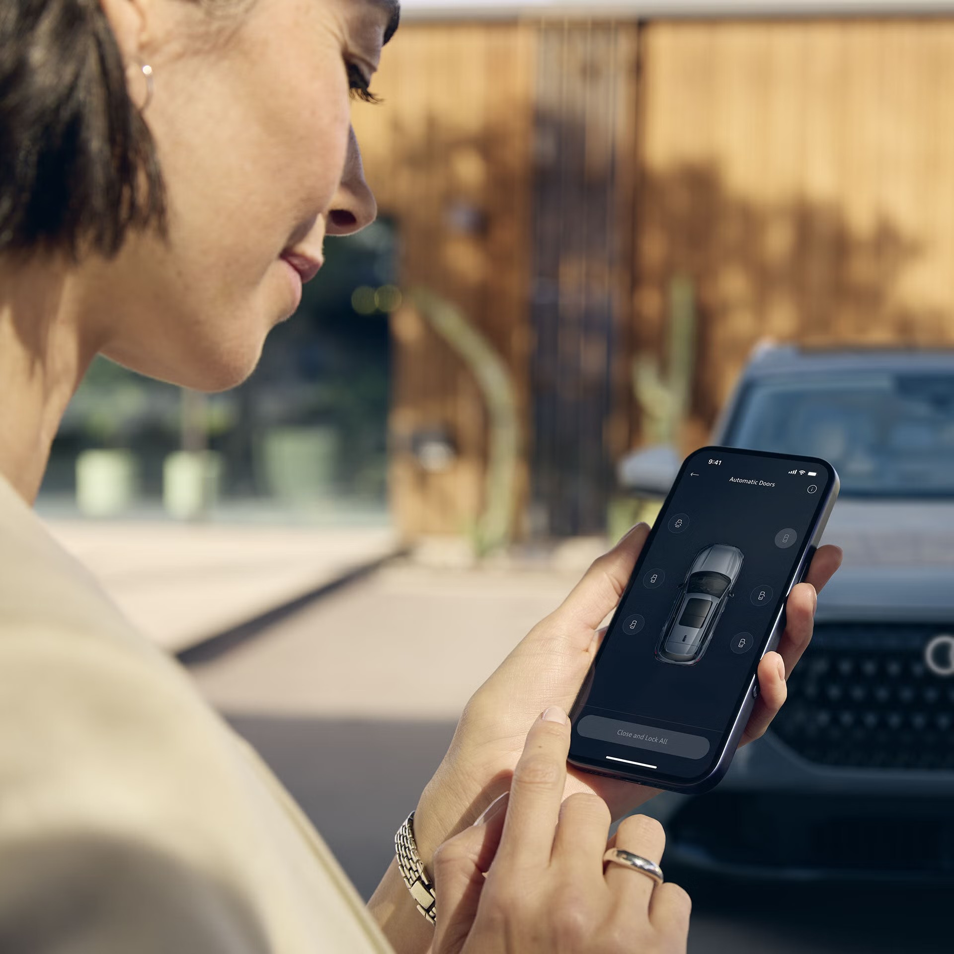 A woman looking at her smartphone in front of the Audi Q7.