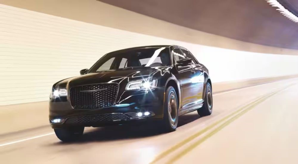 Black 2023 Chrysler 300 driving down a tunnel.