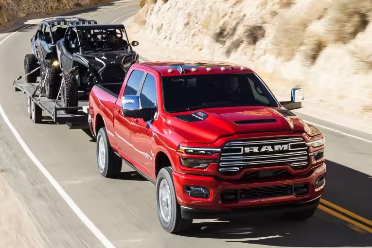 2026 RAM 2500 Exterior Passenger Side Front Angle while Towing Trailer with a Pair of ATVs through the Mountains