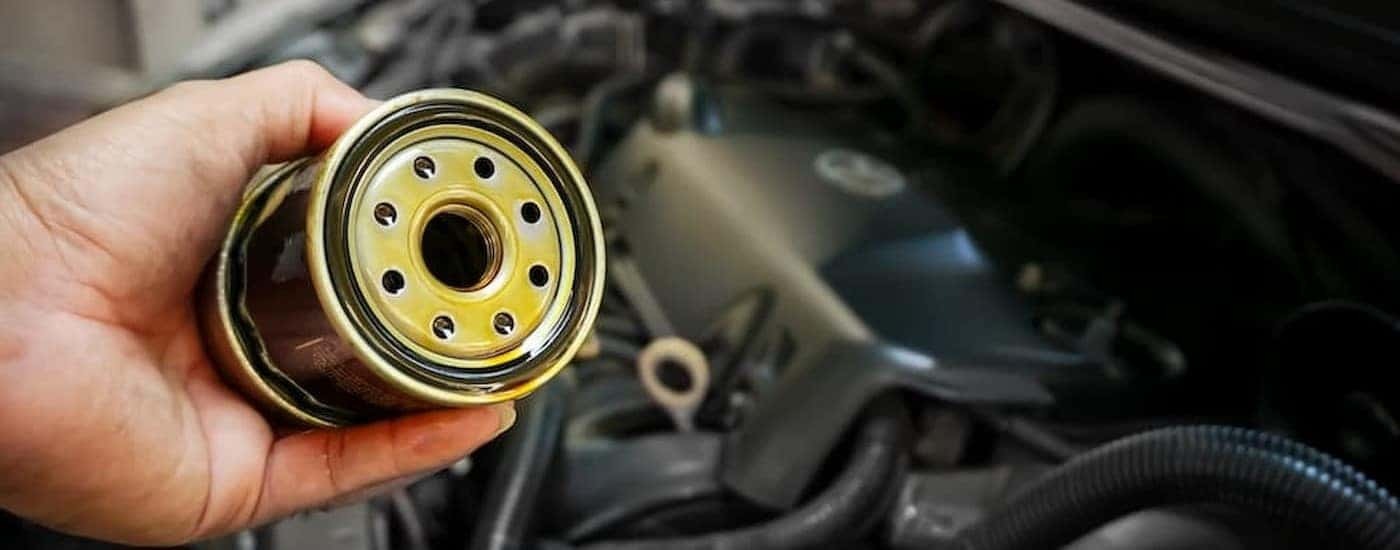 A mechanic is shown holding an oil filter.