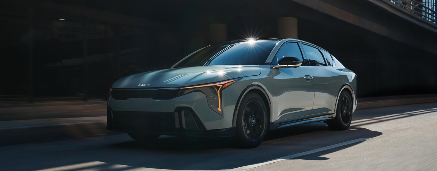 Grey 2025 Kia K4 driving on a city street