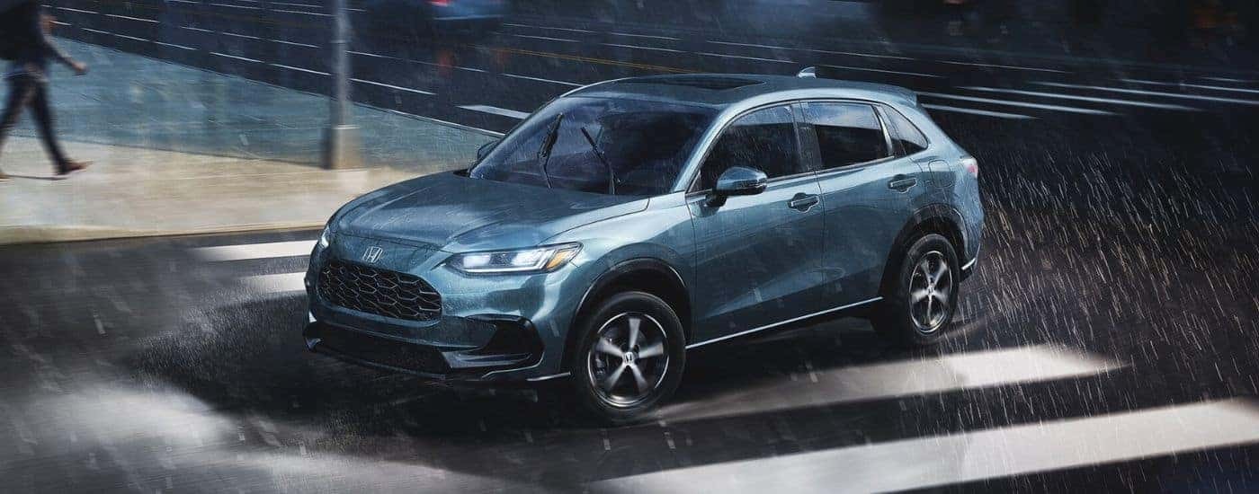 A blue 2025 Honda HR-V driving in rain.