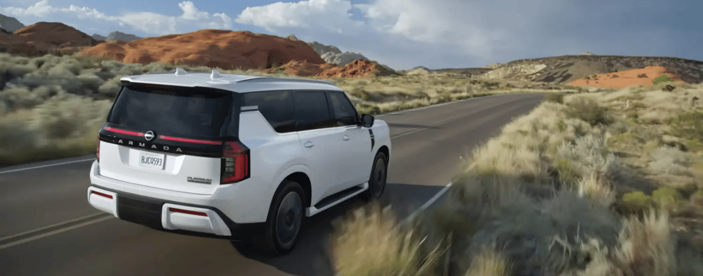 White 2026 Nissan Armada Platinum driving down an open road