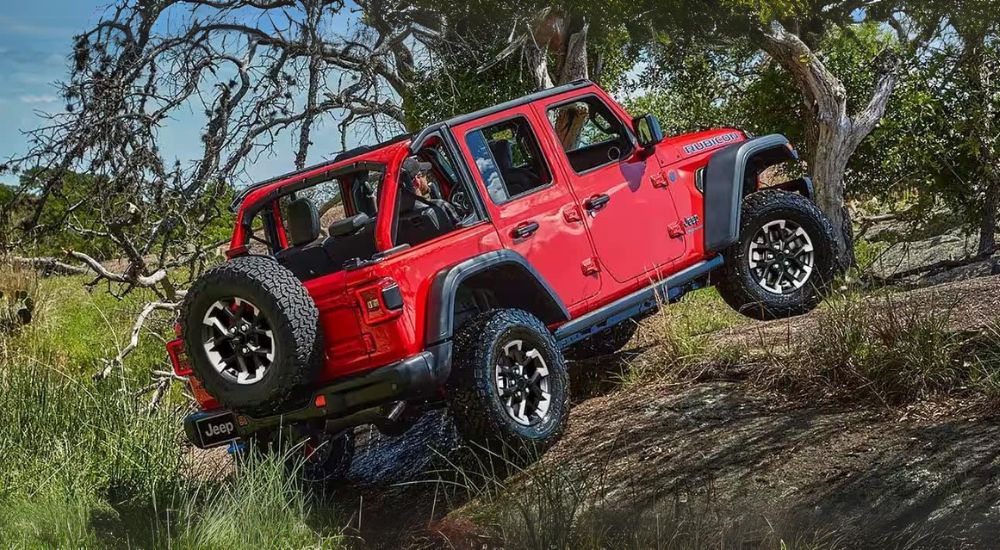 A red 2024 Jeep Wrangler 4xe is shown off-road.