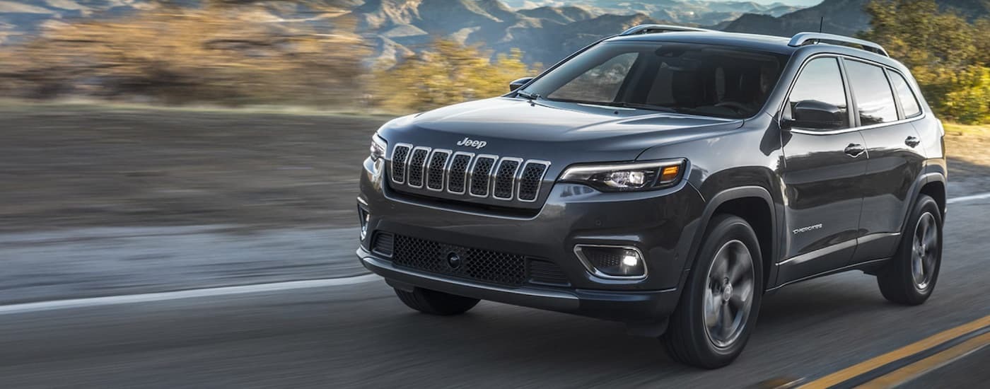 Grey 2021 used Jeep Cherokee for sale driving on an open road