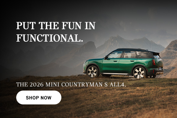 Green Countryman parked on top of a hill.