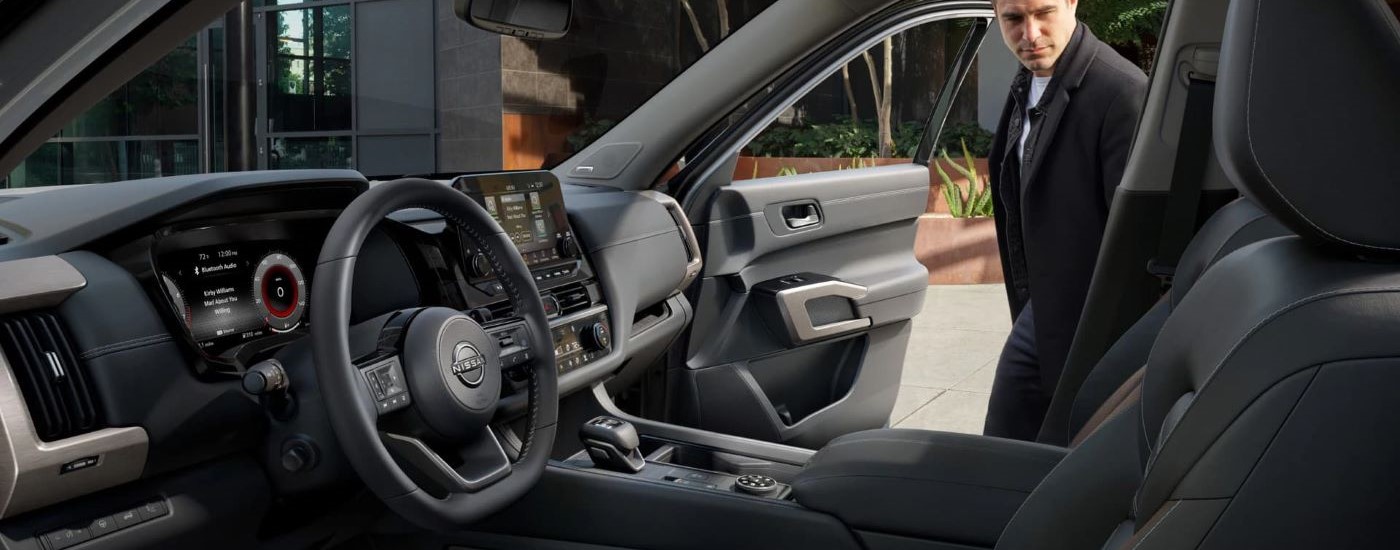 Person opening the passenger side door of a 2025 Nissan Pathfinder Platinum for sale