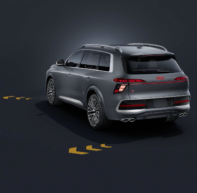 The Audi Q9 SUV, viewed from the front at an angle against a dark background. Flashing animated yellow arrows on the sides of the front and rear illustrate the range of the extended turn signal.