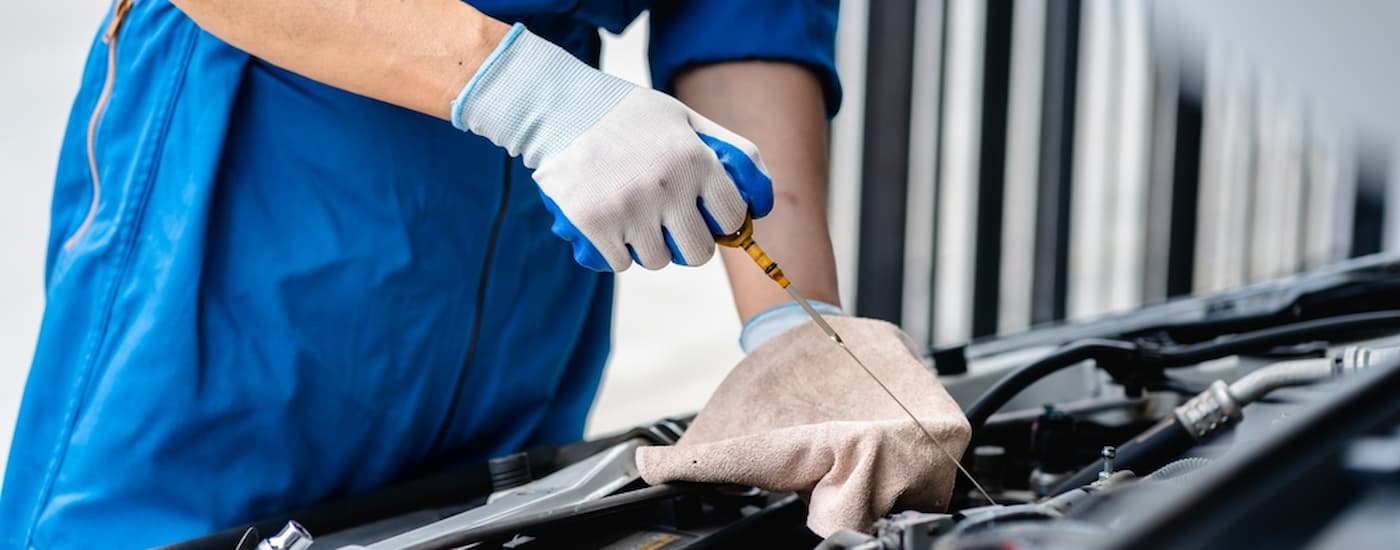 Mechanic pulling an oil wick from an engine.