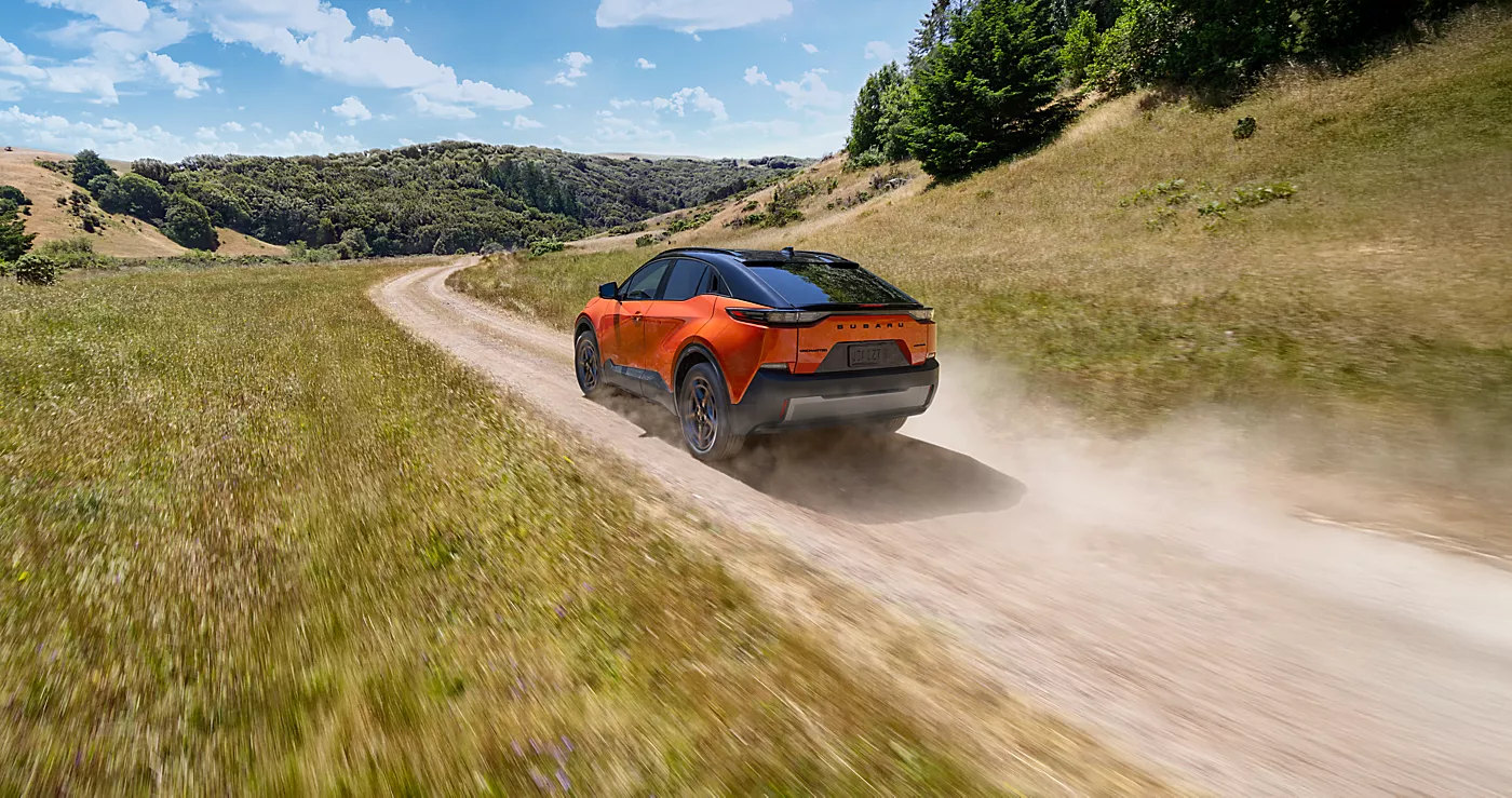 2026 Subaru EV SUV driving on winding mountain road