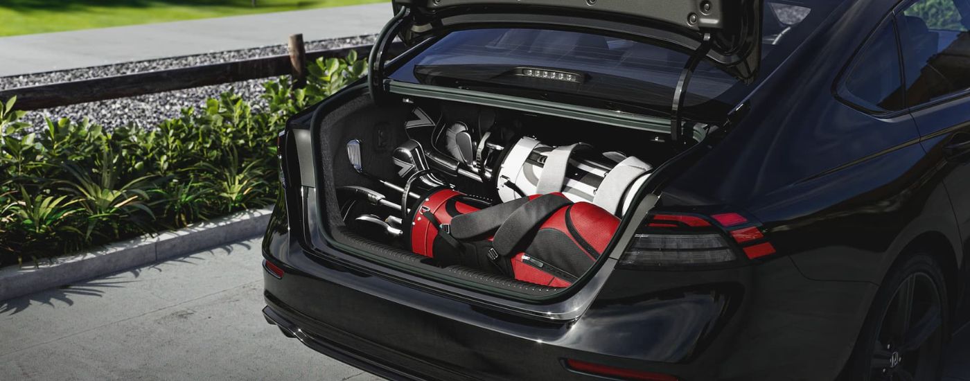 Golf clubs in the trunk of a black 2026 Honda Accord