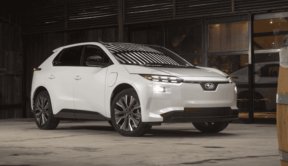 White 2026 Subaru Solterra EV parked inside a modern showroom