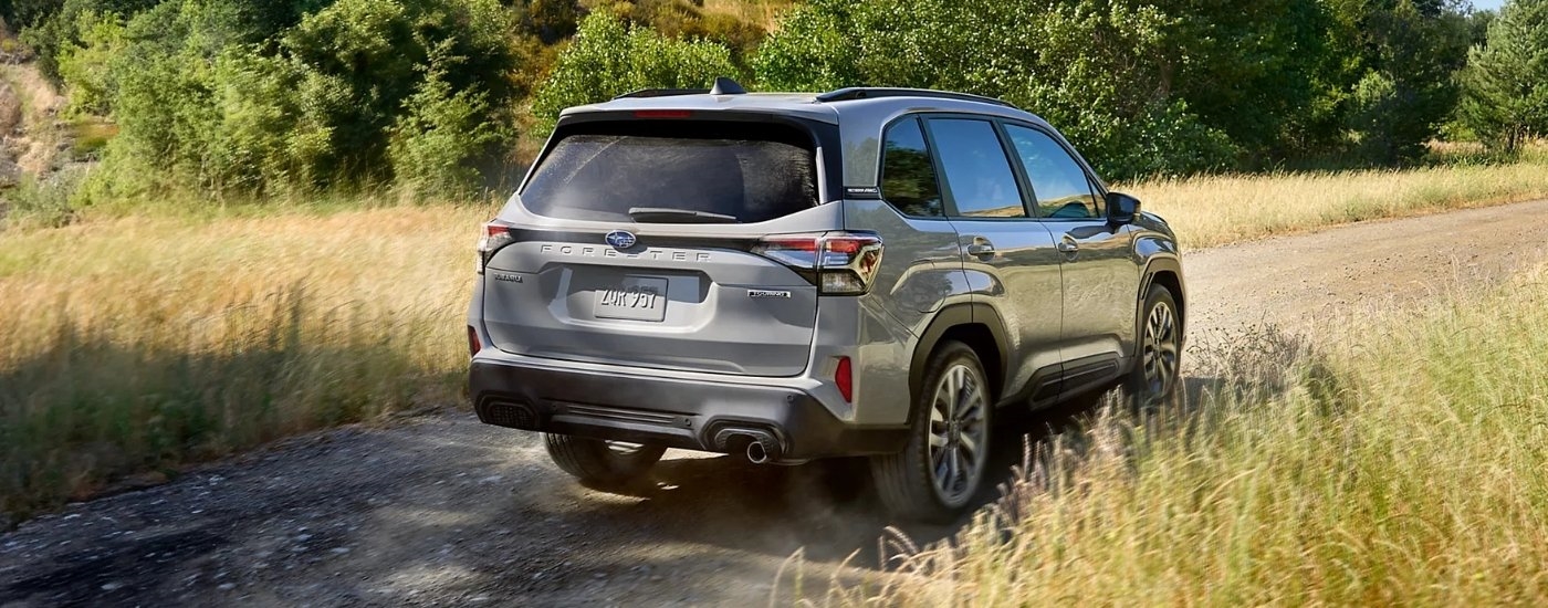 A silver 2025 Subaru Forester Touring is shown on a trail.