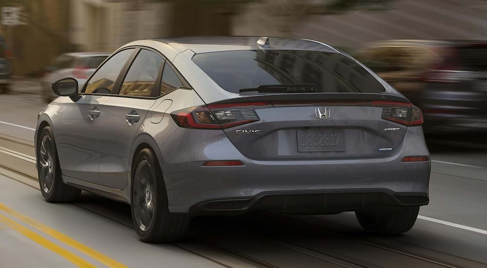 Grey 2026 Honda Civic Hatchback driving on a city street