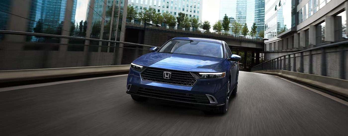 A blue 2025 Honda Accord driving down a city street.