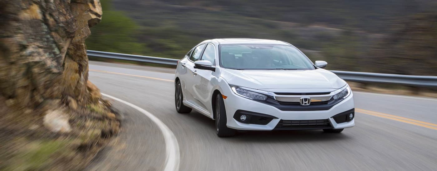 White 2017 Honda Civic driving down an open road.