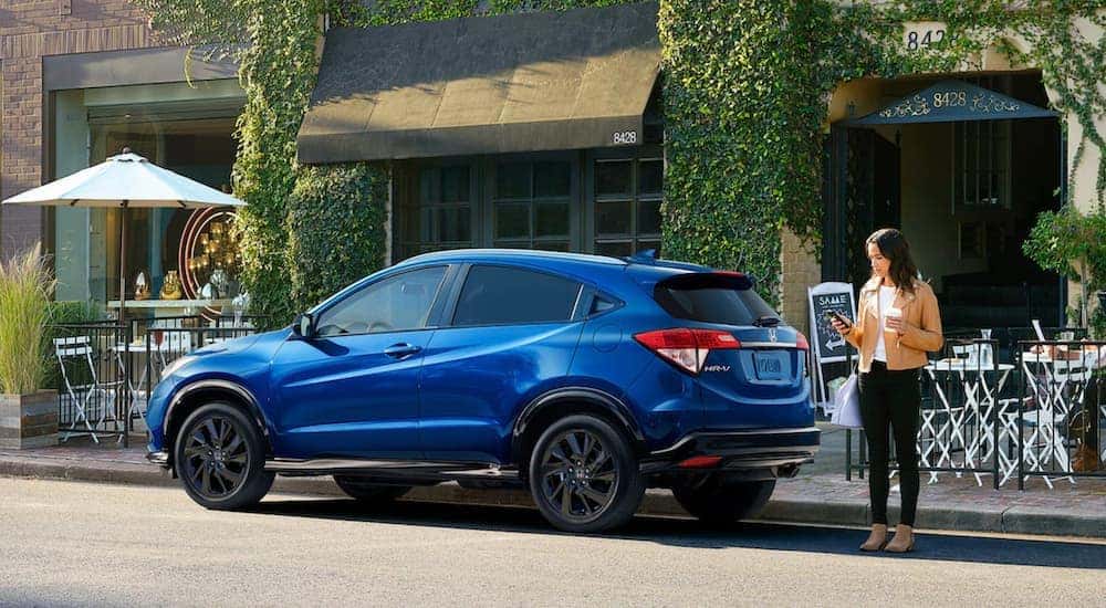 A blue 2021 Honda HR-V is shown from the side, parked in front of a restaurant.