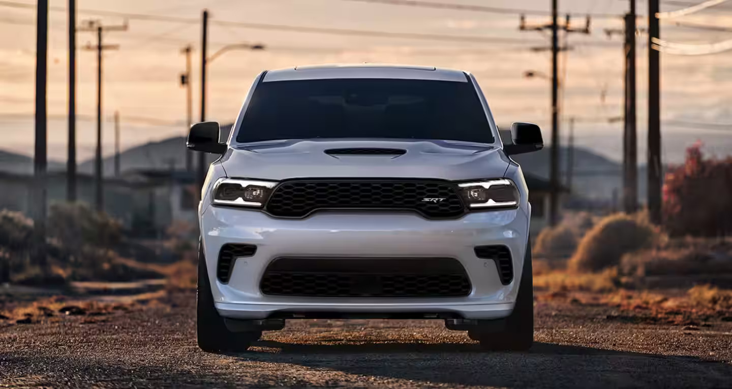 a white suv sitting in the road.