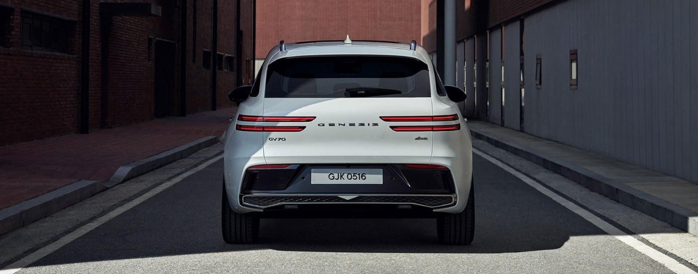 The rear of a white 2025 Genesis GV70 at a dealer.
