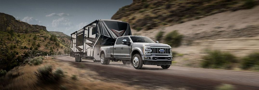 Silver 2025 Ford Super Duty Dually Towing a Trailer