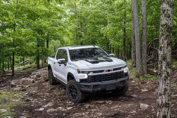 A 2026 grey Chevrolet Silverado 1500 Trail Boss off-roading in the woods