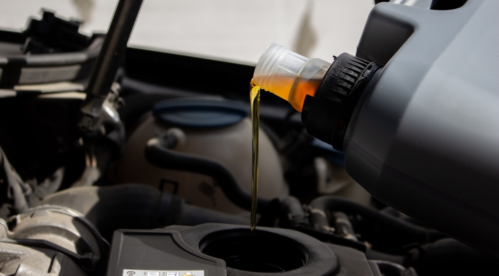 Gray Canister pouring oil into vehicle