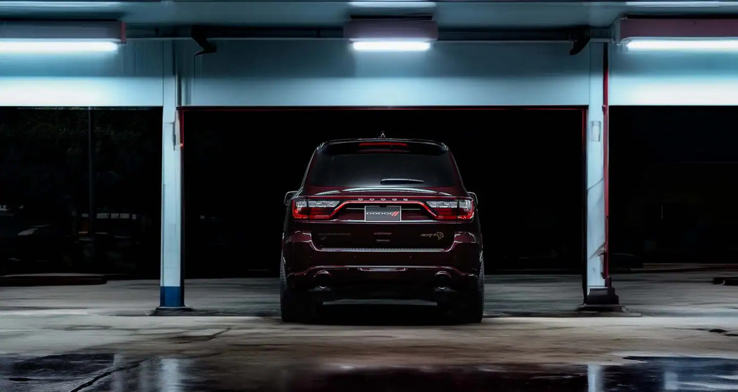 A maroon suv sitting parked.