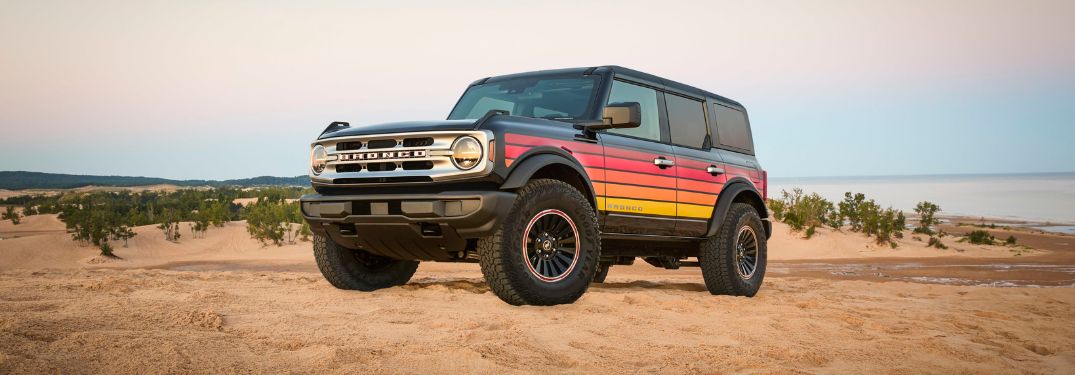 Black 2025 Ford Bronco Free Wheeling Edition with Red, Orange, and Yellow Graphics on a Beach